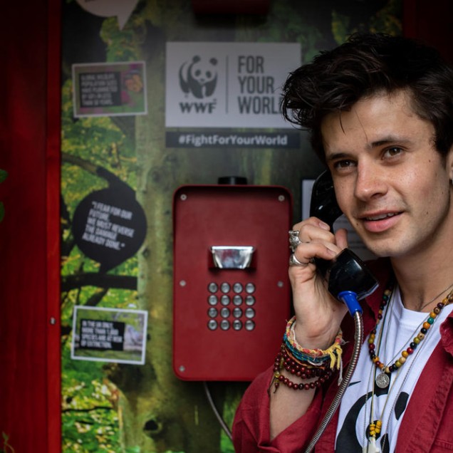 Cel Spellman inside a telephone box inviting the public to leave messages demanding action to their MPs