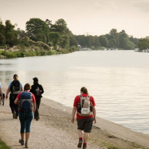 people walking along the Thames river in London