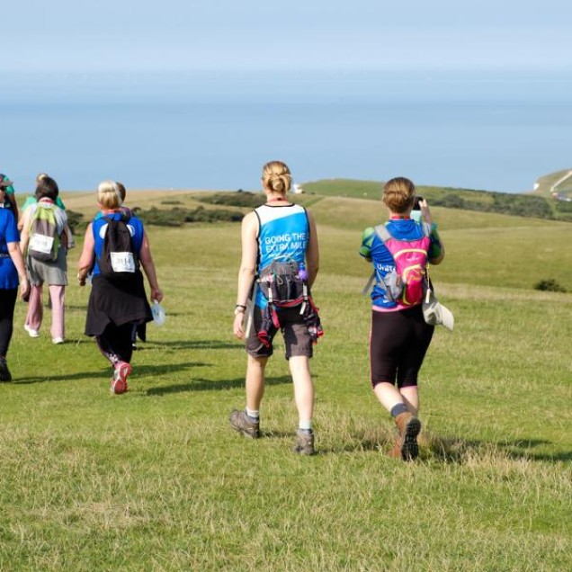 People walking along the South Coast Walk in a sunny day