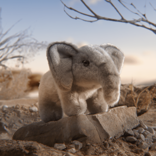 Elephant cuddly toy on a rock in the desert