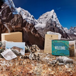 snow leopard welcome pack contents with mountains in the background