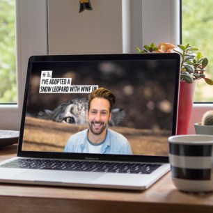 Laptop screen showing man with background image of a Snow Leopard
