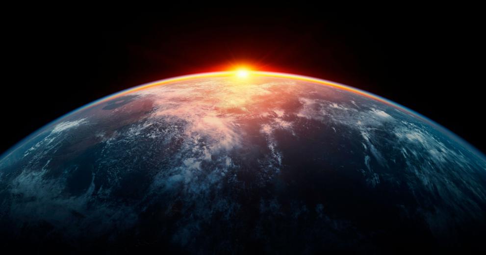 The sun is just rising or setting behind the curviture of the earth, as seen from space.