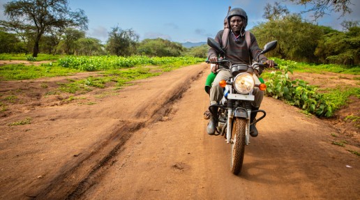 2 Human Wildlife Coexistence Officers riding along a dirt road on a motorbike