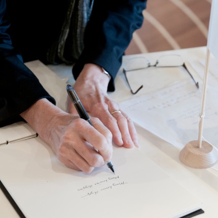 close shot of woman signing document on a table
