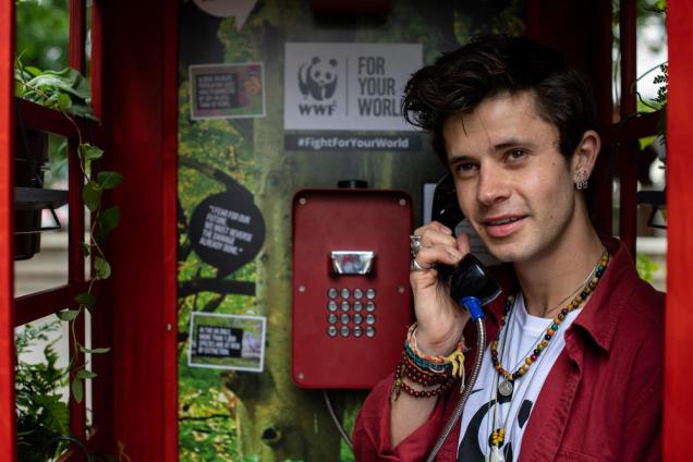 Cel Spellman inside a telephone box inviting the public to leave messages demanding action to their MPs