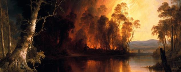 Riverbank with trees on fire in the distance