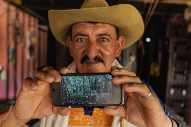 Portrait of man posing with phone displaying jaguar image