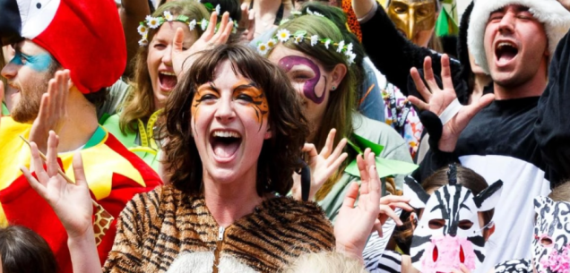Group of people in wildlife-themed fancy dress cheering at an event