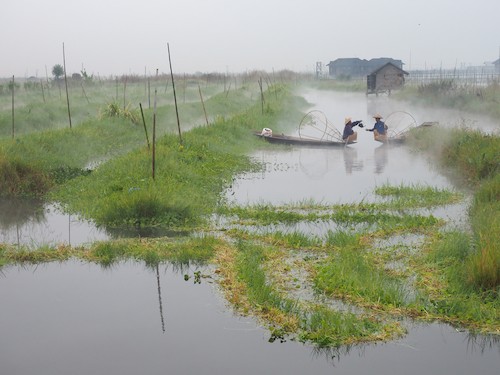 Two fishermen sharing tea in the early morning on Inle Lake, Myanmar