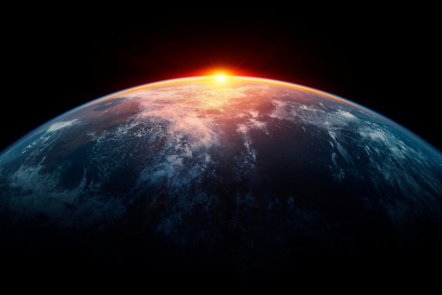 View from space as the sun sets behind the Earth