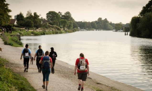 people walking along the Thames river in London