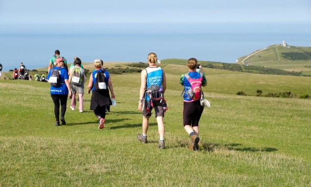 People walking along the South Coast Walk in a sunny day